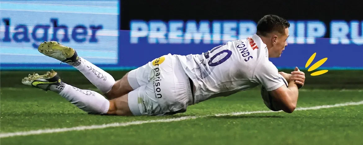 Man diving with rugby ball