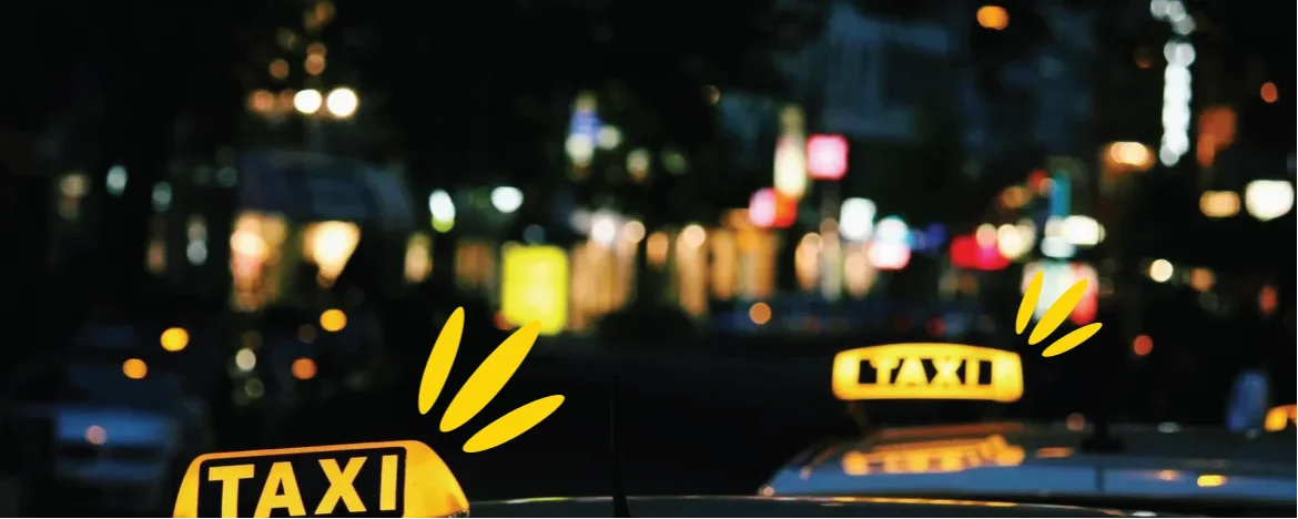 Yellow taxi signs against cityscape