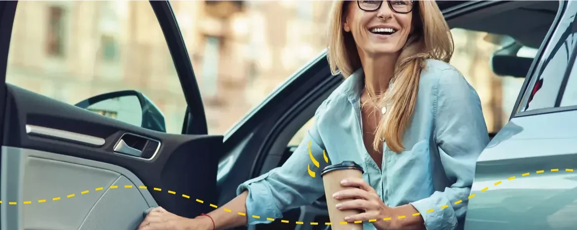 person getting out of car holding coffee