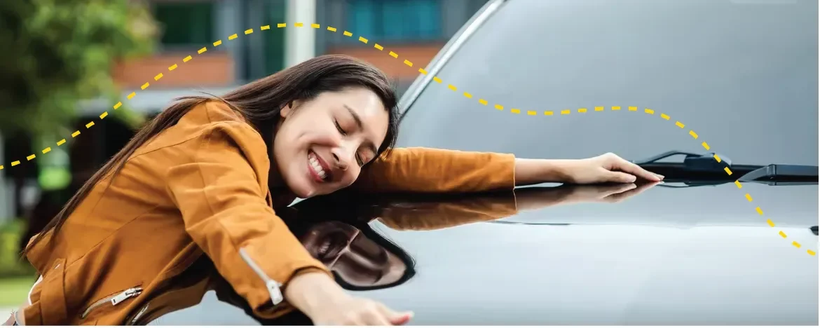 Woman hugs the bonnet of her new lease car