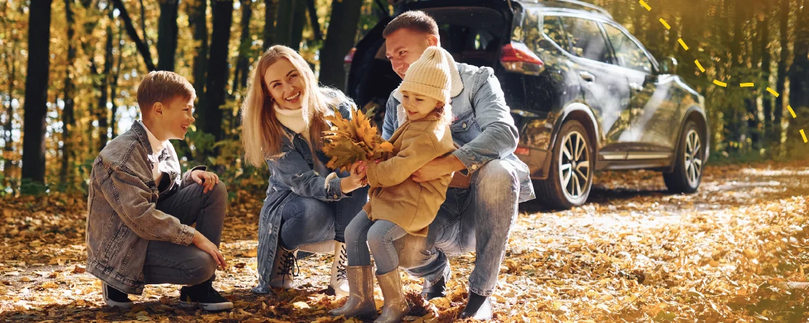 Family outside car in leaves