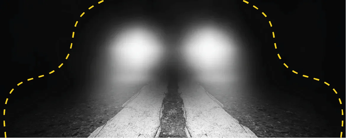 Glowing headlights on a dark road
