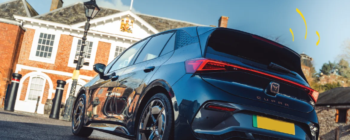Rear shot of CUPRA Born parked outside a large house