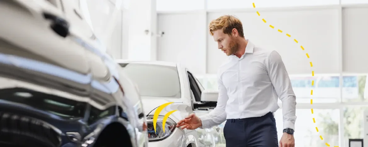 Man at dealership looking at in stock cars