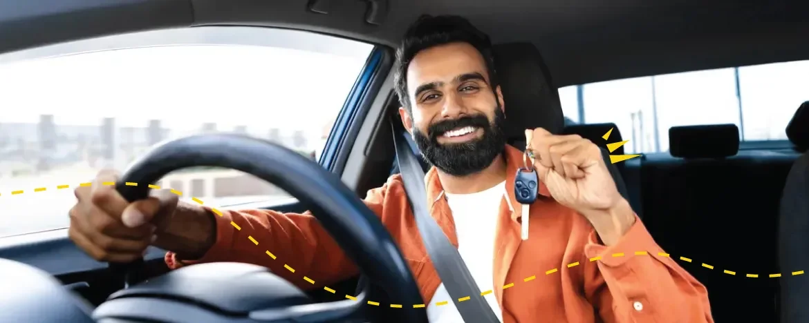 Happy man in driving seat holds up keys 