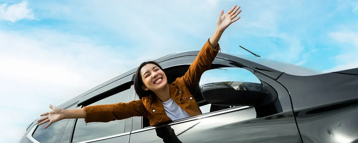 Happy lady leaning out of car window