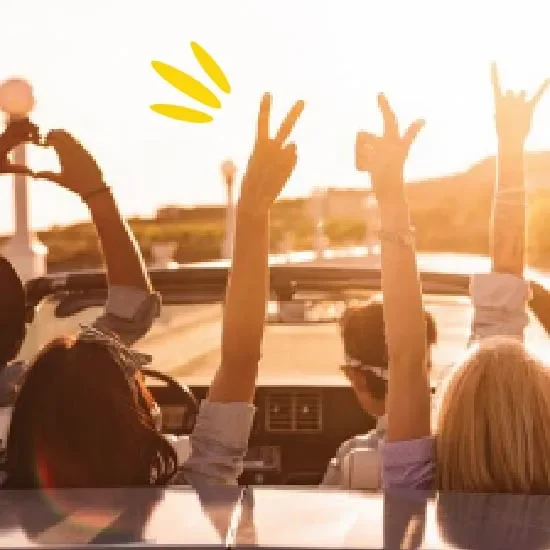 People with hands in the air in a car