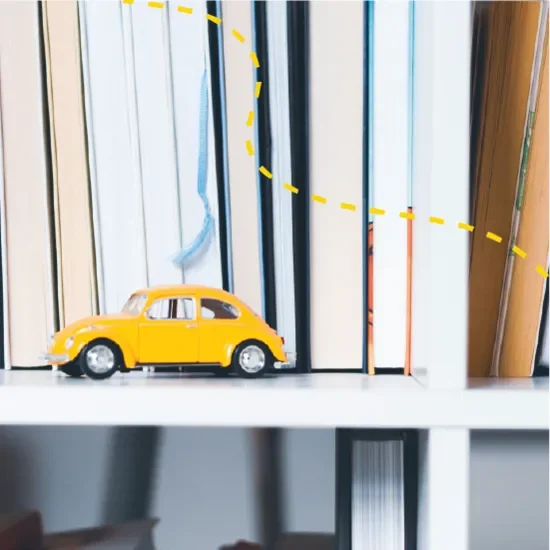 Yellow toy car in front of bookshelf