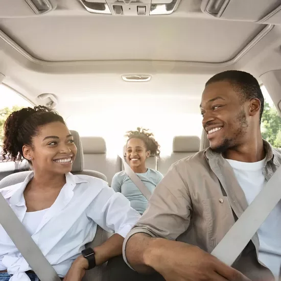 Family sat in car smiling
