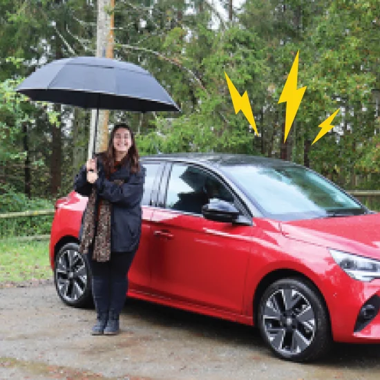 woman with umbrella next to Corsa-e