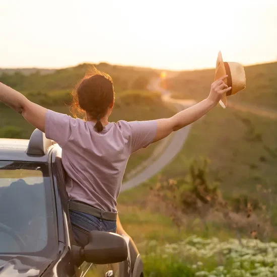 person leaning out car window in the sun