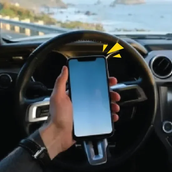 a phone being held in front of a steering wheel
