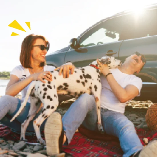 couple-with-dog-sat-alongside-suv-car