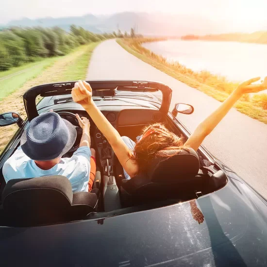 woman and man in car with the roof down
